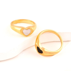 Close-up of 18K gold plated rings with black and white heart epoxy resin inlays