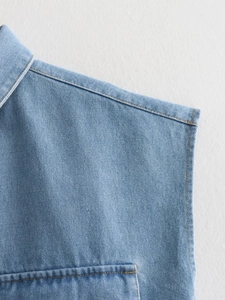 Gros plan d'une chemise en jean bleu clair montrant la couture et le col polo chic