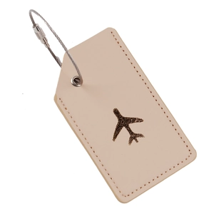 Detail of beige leather luggage tag with gold airplane stamping and steel wire cable