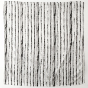 Close-up of black and grey striped linen texture scarf with gold glitter and fringe edge