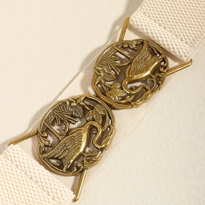 Detail of bronze crane buckles on a beige elastic waist belt for vintage dresses