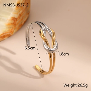 Detail of two-tone knot bangle in 18K gold and silver steel on beige background