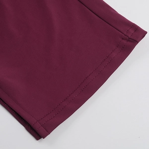 Détail macro d'une couture double aiguille sur le tissu bordeaux du combishort d'été