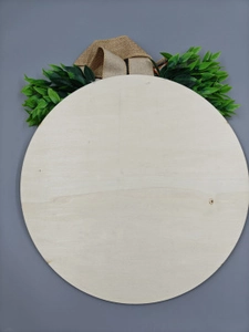 Detail of round wooden door sign with burlap bow and faux greenery decoration