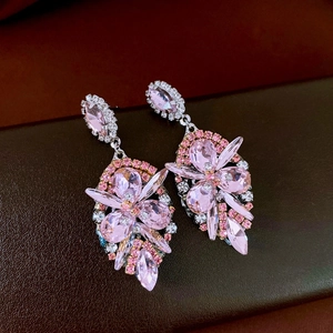 Detailed view of pink crystal drop earrings with silver settings and rhinestones