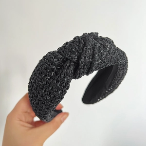 Détail du serre-tête tressé noir avec nœud central montrant la texture paille de qualité