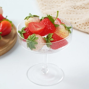 Realistic artificial strawberries and sliced fruit model set in a clear glass goblet