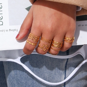 Detail of gold-plated woven and star pattern ring set worn on a model's hand