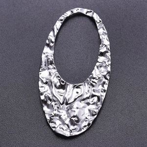 Macro shot of silver-toned 304 stainless steel teardrop pendant with hammered texture detail
