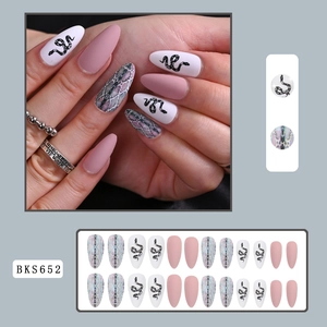 Macro detail of long stiletto press-on nails with pink matte and snake pattern designs