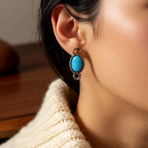 Close-up of vintage resin oval earrings with turquoise stone and silver rope pattern