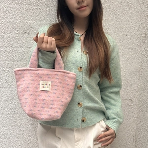 Detail of pink plush knit tote bag with colorful dots and a white woven label patch