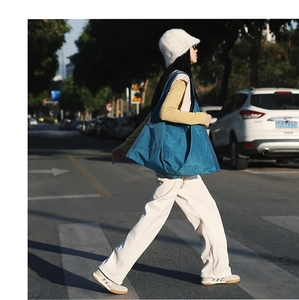 Chic blue nylon tote bag for women shown in an urban street style outdoor setting