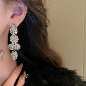 Close-up of vintage textured silver drop earrings with four irregular geometric metal discs