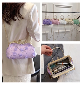 Detail view of floral embroidery clutch bag with sequins and golden metal chain strap