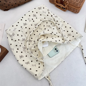 Interior view of corduroy tote bag showing large capacity with phone and earbuds