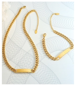 Detail of 18k gold plated Cuban chain necklace and bracelet set with rectangle bar