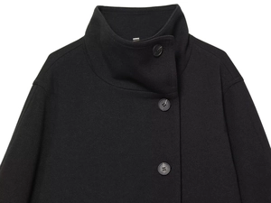 Detail of a black wool short coat featuring a stand collar and large round buttons