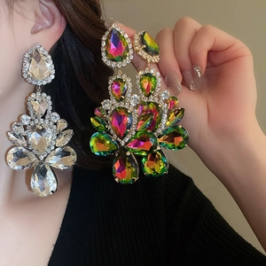 Close-up of oversized teardrop crystal statement earrings worn for a luxurious look