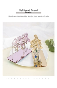 Macro shot of acrylic hanger-style earring stand in purple and gold with small hooks