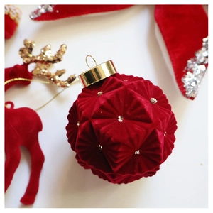 Macro shot of geometric faceted dark red velvet Christmas ball with silver glitter dots