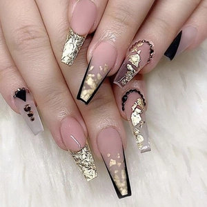Long coffin press-on nails in nude pink with black French tips, gold foil, and chain accents