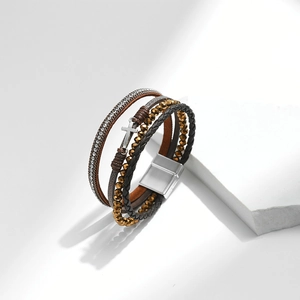 Macro detail of multilayer PU leather bracelet with crystal chains and silver cross charm