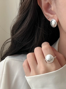 Detail of silver hammered texture ring and earrings set on model with minimalist style