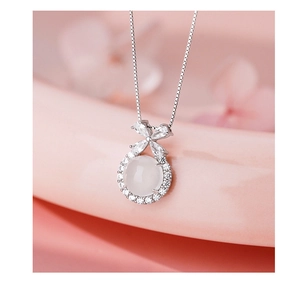 Macro shot of silver butterfly necklace with white agate stone and zircon detailing