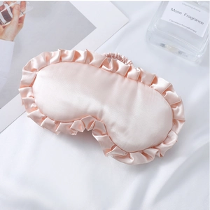 Details einer rosa Schlafmaske aus Satin mit eleganten Rüschen und weicher Textur