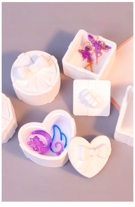 Detail of white silicone resin molds for heart and gift box shaped storage containers