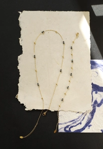 Vista dettagliata della collana artigianale con perline blu stellato e catena in acciaio dorato