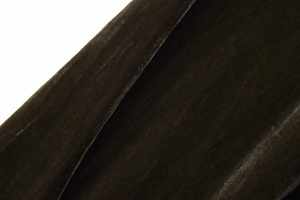 Dettaglio in macro del tessuto velluto oliva con trama fitta e morbida lucentezza premium