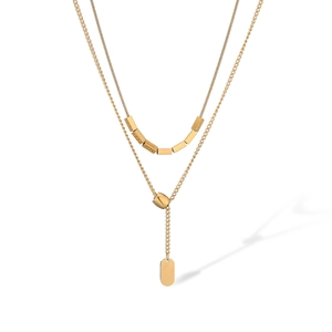 Close-up of double-layered gold necklace with snake chain and rectangular metal beads
