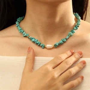 Detail of beaded necklace with blue turquoise chips and a white baroque pearl focal