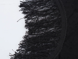 Close-up of black lace fabric and delicate fringe detail on the y2k off-shoulder dress