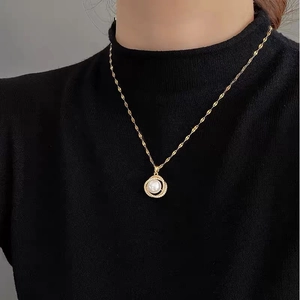 Elegant gold-plated necklace with micro-pave rhinestone circle and pearl pendant on a model