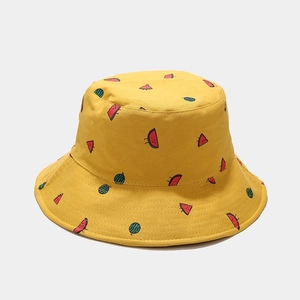 Close-up of yellow bucket hat featuring detailed watermelon embroidery and canvas texture