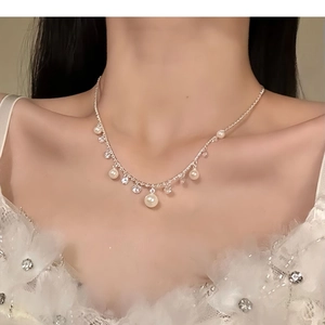 Detail view of water-drop pearl necklace with sparkling cubic zirconia on female neck