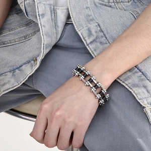 Men's silver and black stainless steel bicycle chain bracelet on a male wrist