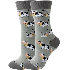 Detail view of cow pattern novelty mid-calf socks in grey and white textile fabric