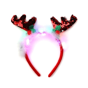 Detail of LED Christmas reindeer antler headband with sequins, green leaves and white feathers