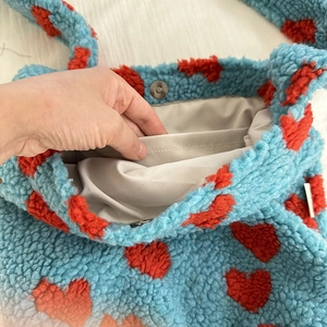 Detail view of sky blue fleece tote showing magnetic clasp closure and inner pocket