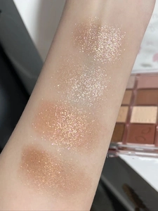 Swatch dettagliati su braccio di palette ombretti 20 colori con texture glitter e shimmer