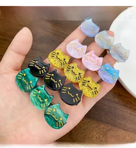 Detail of glitter cat hair clips in multiple colors with gold facial features