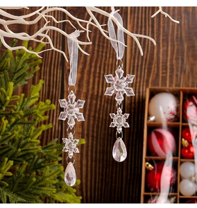 Macro detail of layered acrylic snowflake ornaments with teardrop crystal pendants