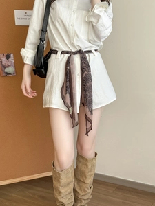Détail d'un foulard en soie vintage à motif cachemire porté comme ceinture sur robe