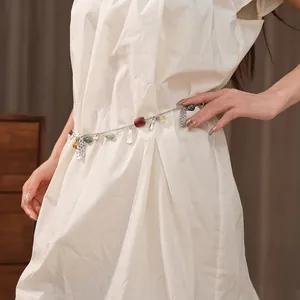 Retro ethnic metal waist chain with colorful beads and engraved charms on white dress
