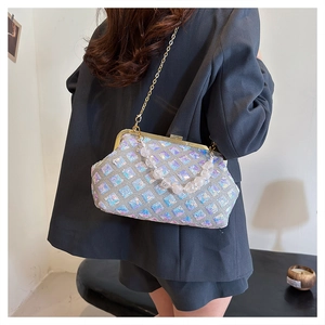 Detail of silver sequin handbag featuring pearl handle and metallic chain strap