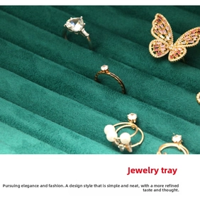 Detail of dark green velvet jewelry tray with slots for rings and brooches